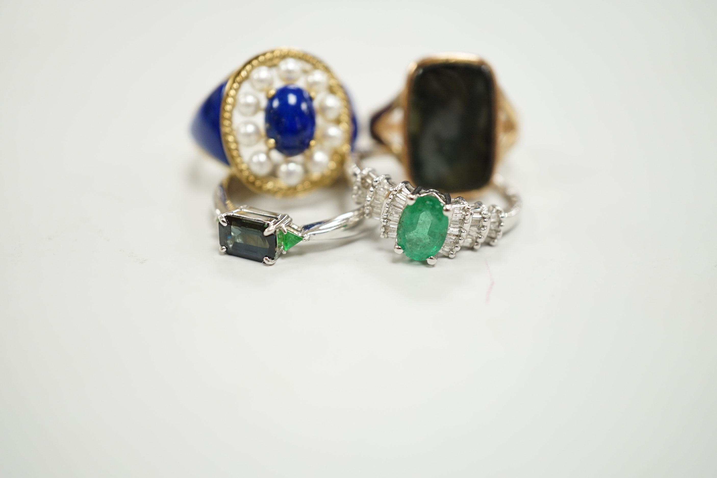 A modern 750 white metal and three stone gem set ring, two 9ct gold and gem set rings including lapis and seed pearl and one other yellow metal ring.